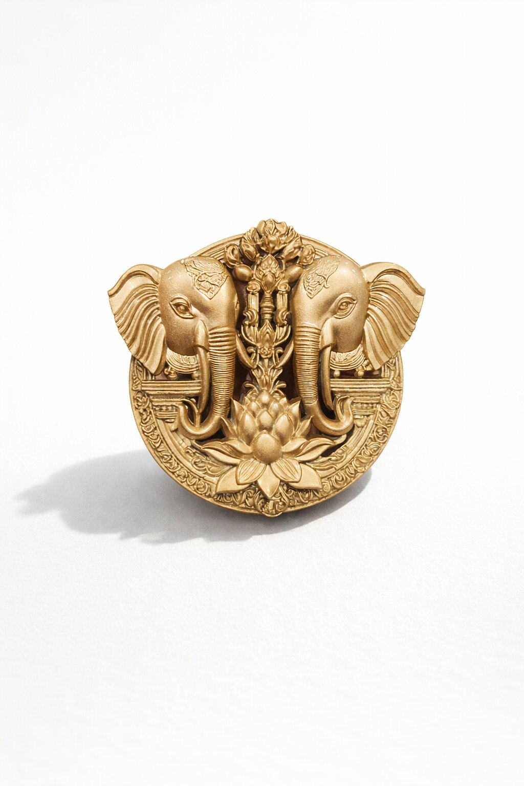 Gold-tone twin elephant brooch featuring a lotus flower motif and intricate traditional detailing, ideal for weddings and festive occasions.