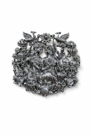 Silver-tone Radha Krishna brooch featuring intricate floral motifs, peacocks, lotus flowers, and crystal embellishments, ideal for weddings and festive occasions.