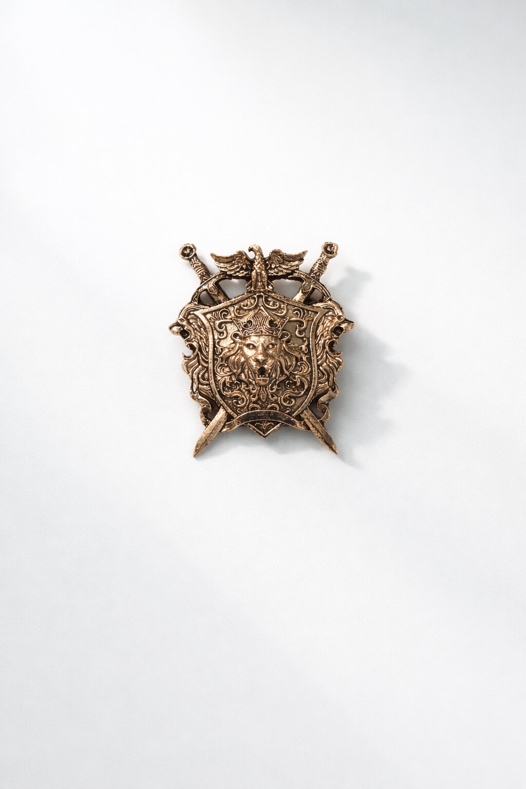 Antique gold lion crest shield brooch featuring a crowned lion emblem, crossed swords, and intricate royal detailing, ideal for wedding and ceremonial wear.