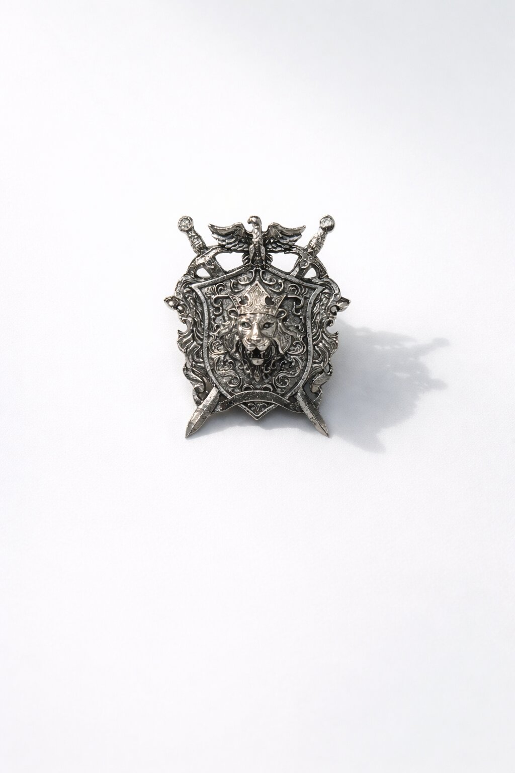 Silver-tone lion crest shield brooch featuring a crowned lion emblem, crossed swords, and intricate royal detailing, perfect for wedding and formal wear.