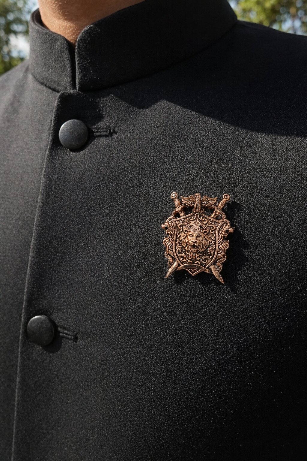 Antique gold lion crest shield brooch featuring a crowned lion emblem, crossed swords, and intricate royal detailing, ideal for wedding and ceremonial wear.