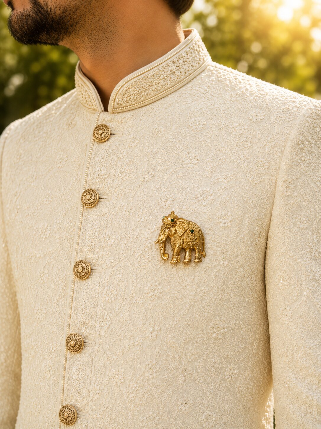 Gold-tone elephant brooch featuring intricate traditional detailing and green gemstone accents, ideal for wedding and festive wear.