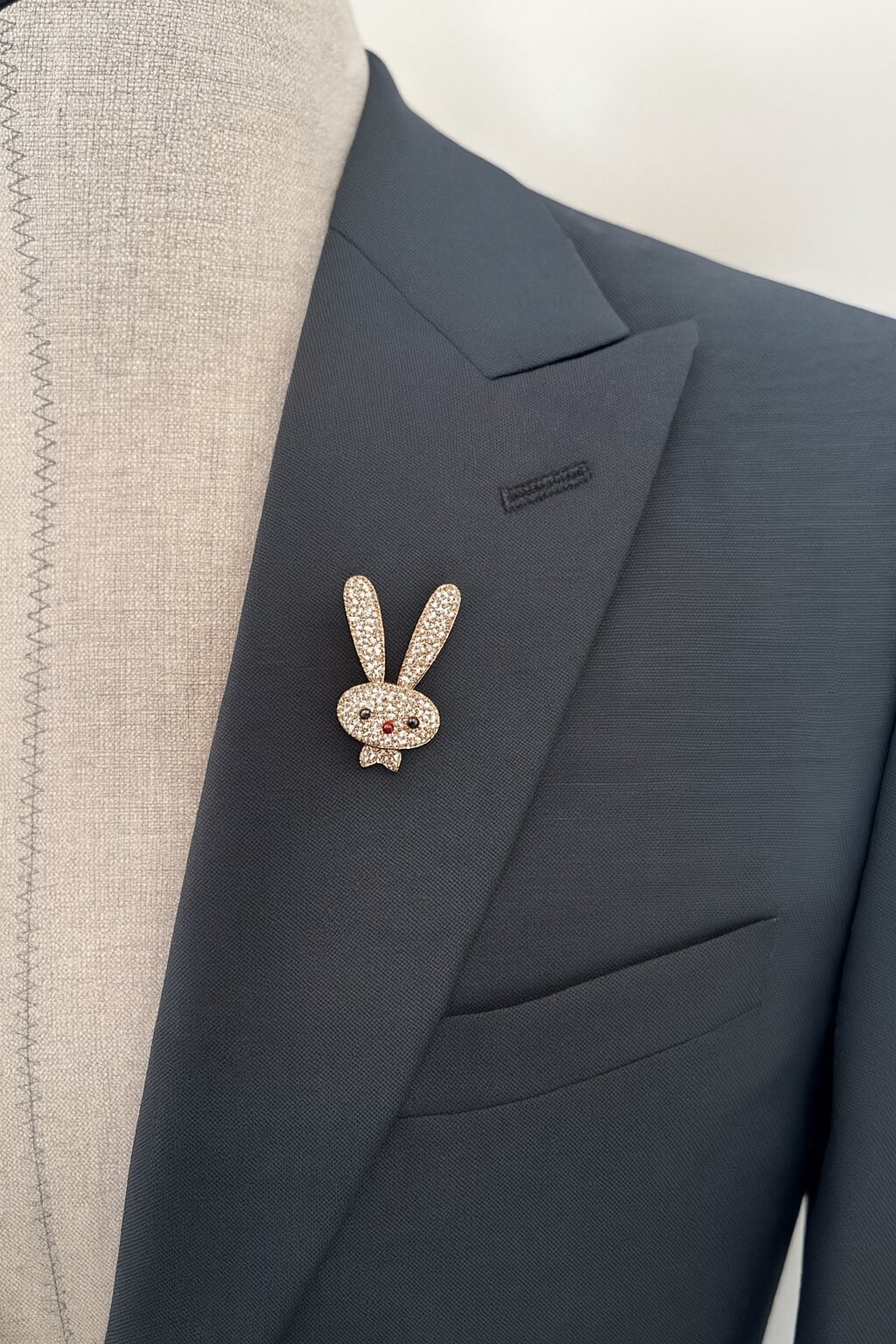 Gold-tone bunny brooch embellished with sparkling clear crystals, black crystal eyes, and a red crystal nose.
