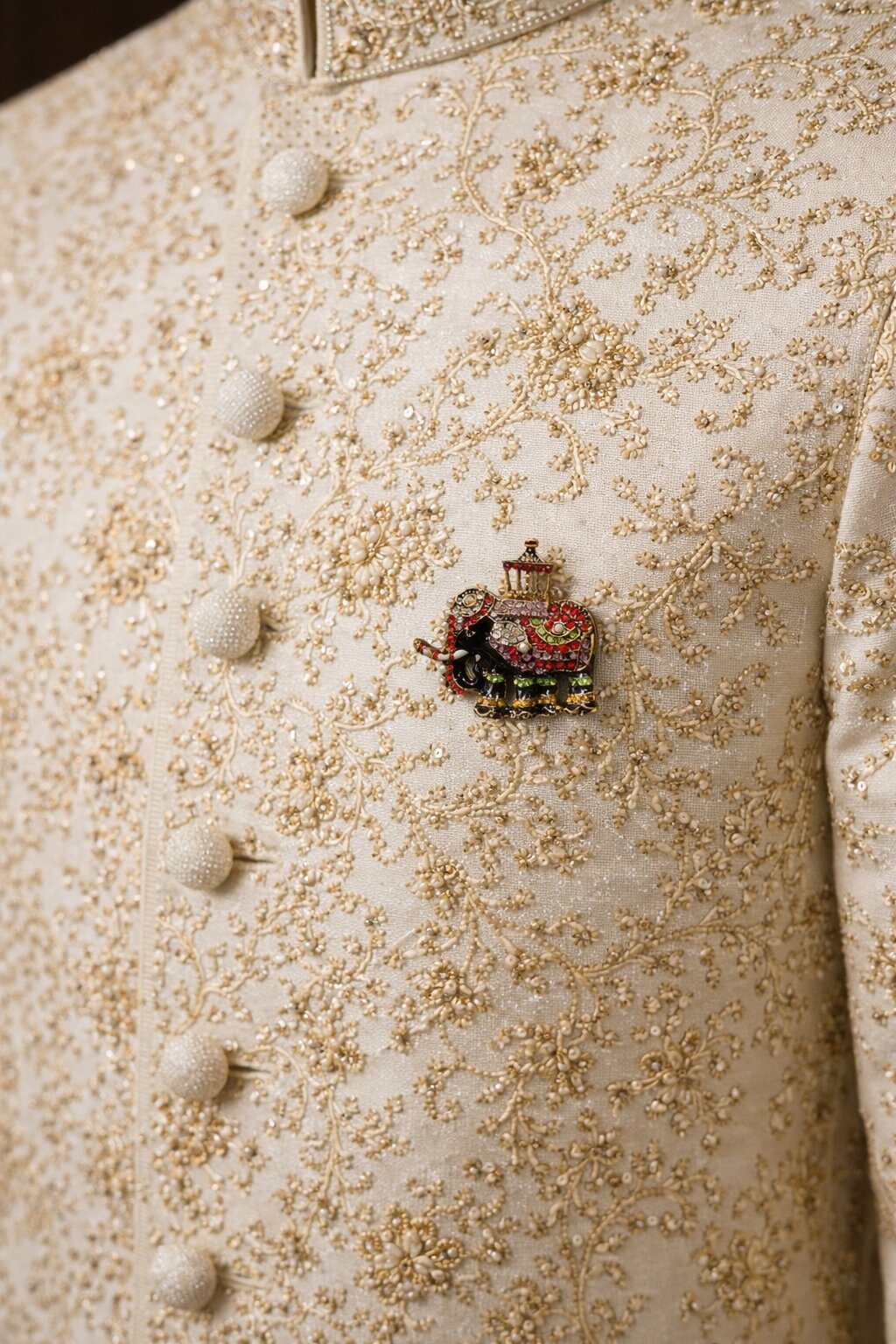 Multicolor crystal elephant brooch with pearl accents and decorative howdah in an antique gold-tone finish.