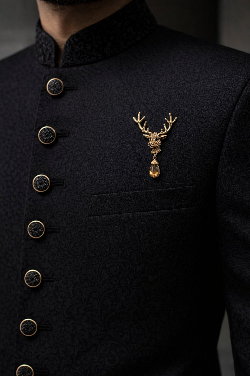 Gold-tone deer head brooch with detailed antlers, amber crystals, black eyes, and dangling teardrop crystal pendant.