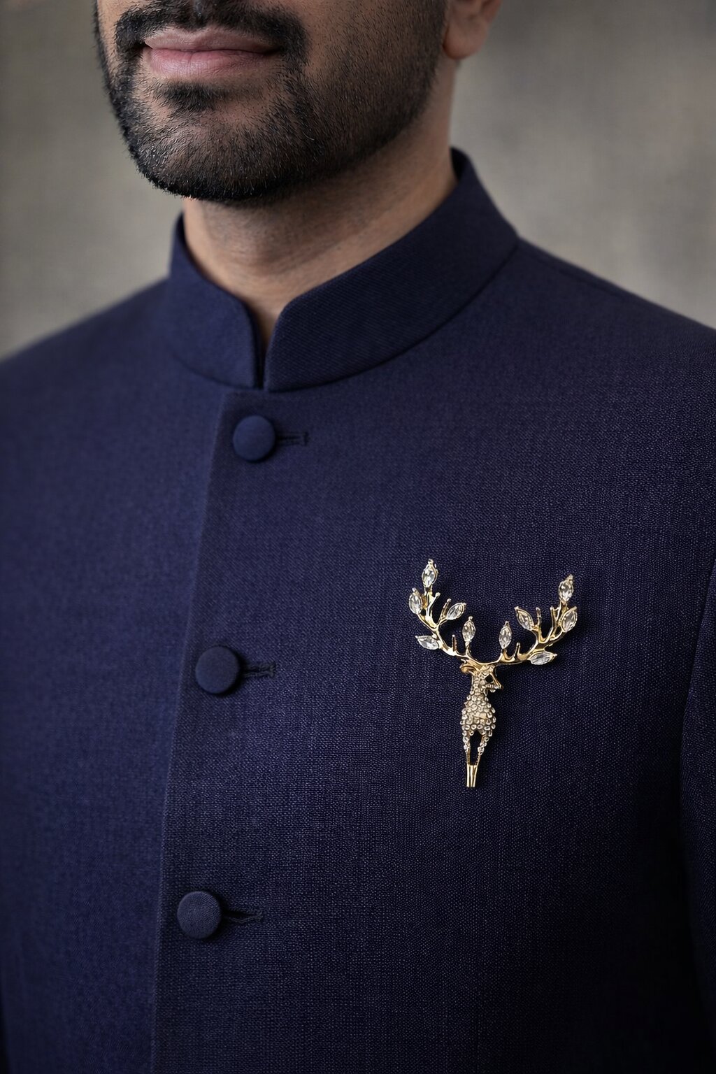 Gold-tone stag brooch embellished with clear crystals and crystal-accented antlers in an elegant luxury design.