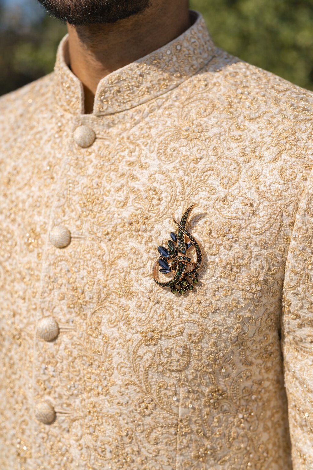 Rose gold floral crystal brooch with black marquise-cut stones, green crystal accents, and an elegant swirl design.