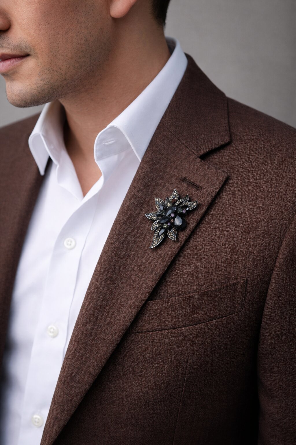 Floral crystal brooch with smoky black gemstones, sparkling crystal accents, and intricate gunmetal-tone leaf detailing.