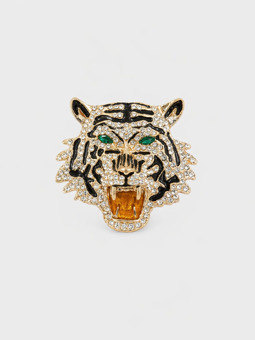 Gold-tone roaring tiger brooch with clear crystals, black enamel stripes, green eyes, and amber-colored mouth detail.