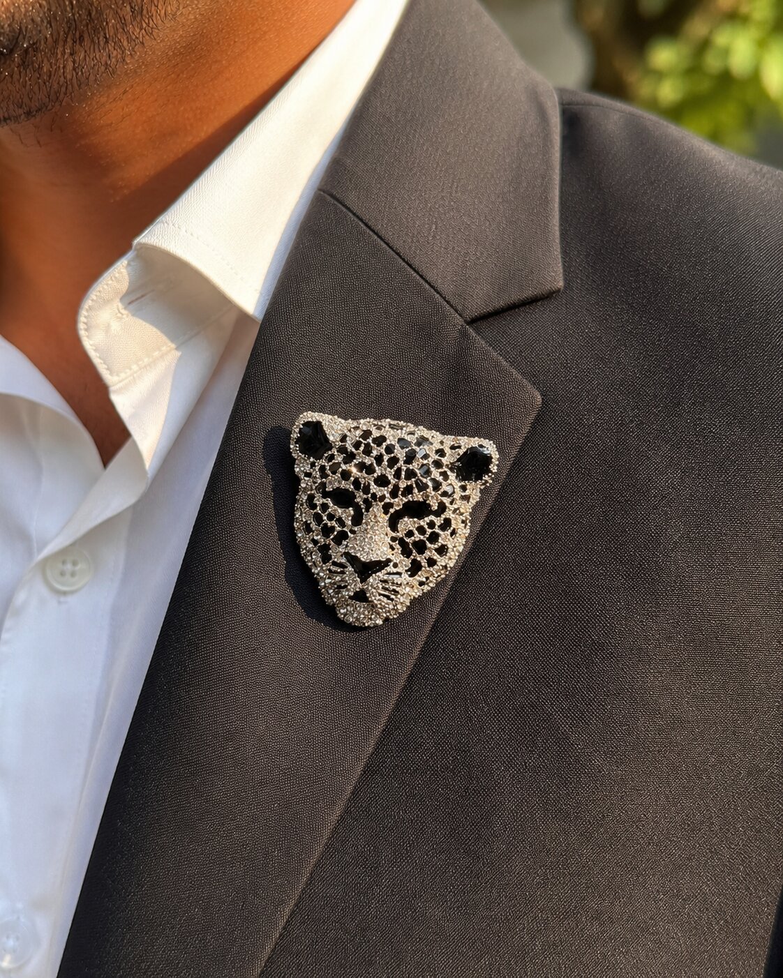 Leopard face brooch with clear crystals, black enamel detailing, and silver-tone finish.