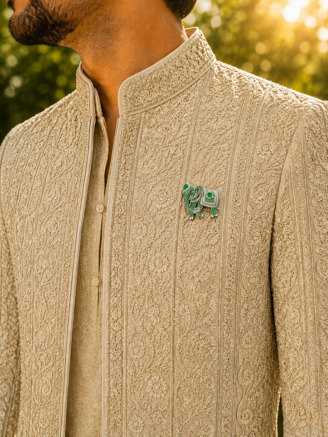 Green elephant brooch with crystal embellishments and emerald-colored gemstone accents.