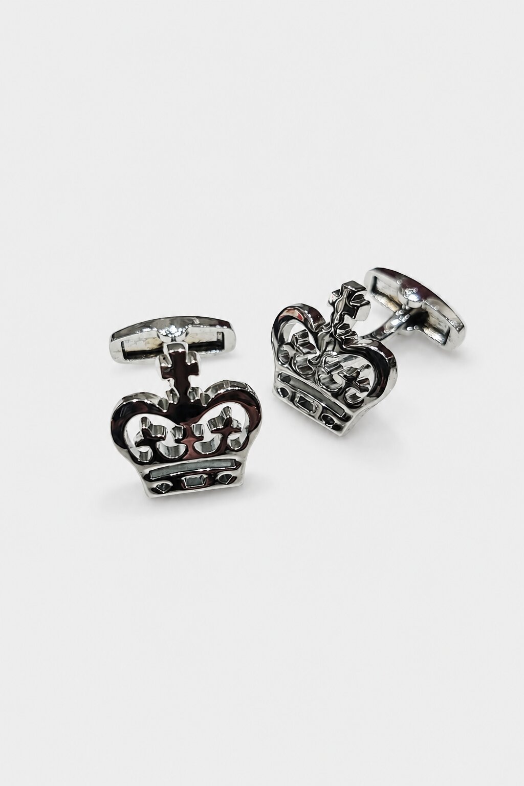 Silver-tone crown-shaped cufflinks with intricate royal detailing for men's formal accessories.