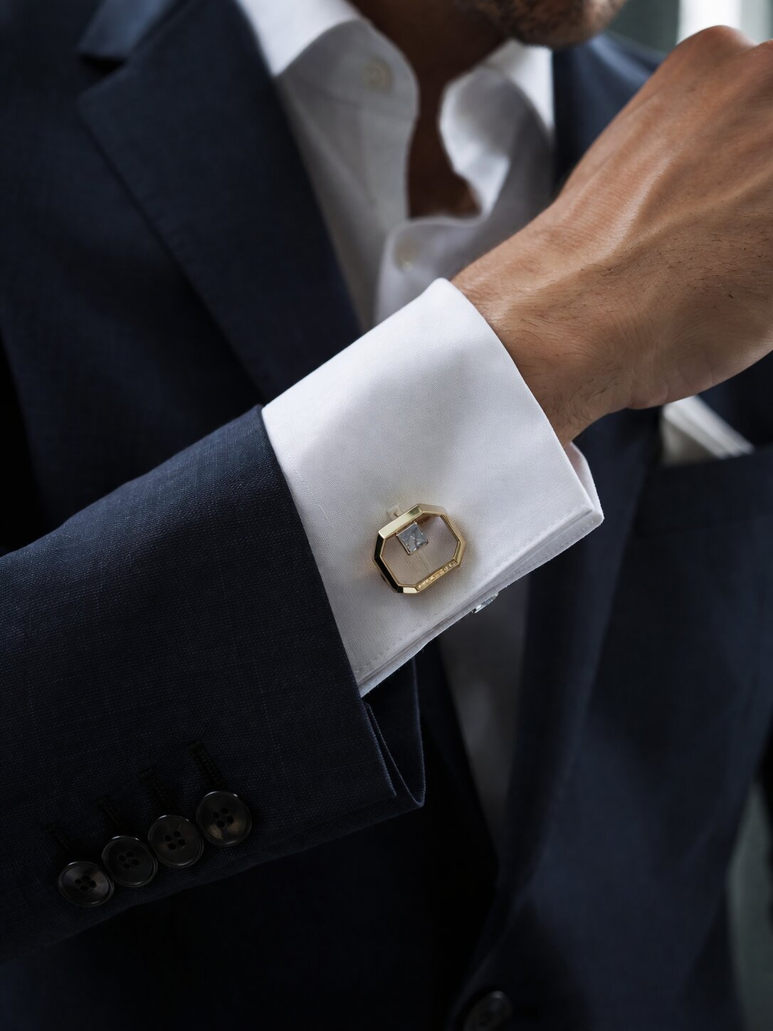 Gold octagonal cufflinks with black enamel face and crystal accent in a polished luxury finish.