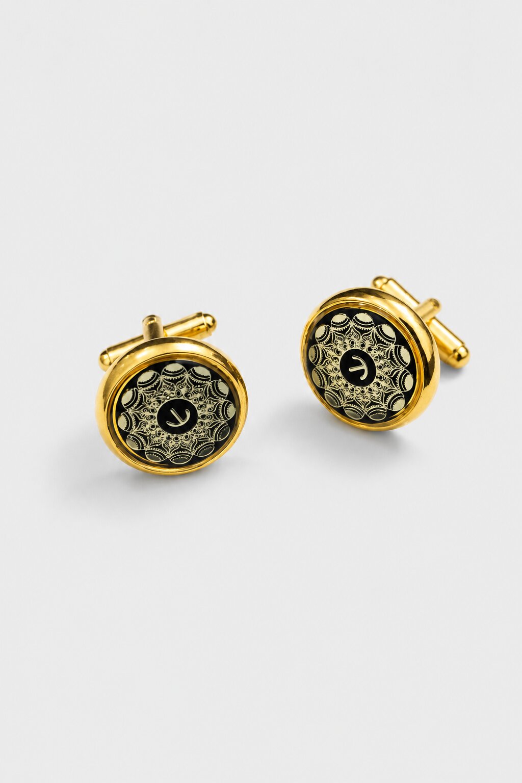 Gold round cufflinks with black background and intricate ornamental pattern for men's formal shirts.