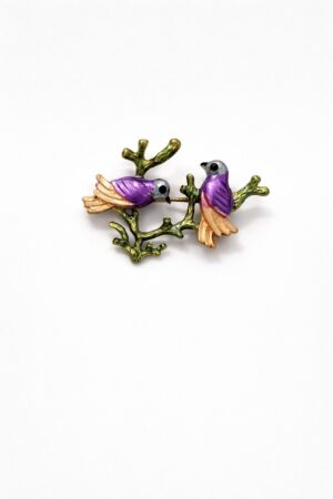 Enamel brooch with two purple birds perched on a green branch with gold-tone details.