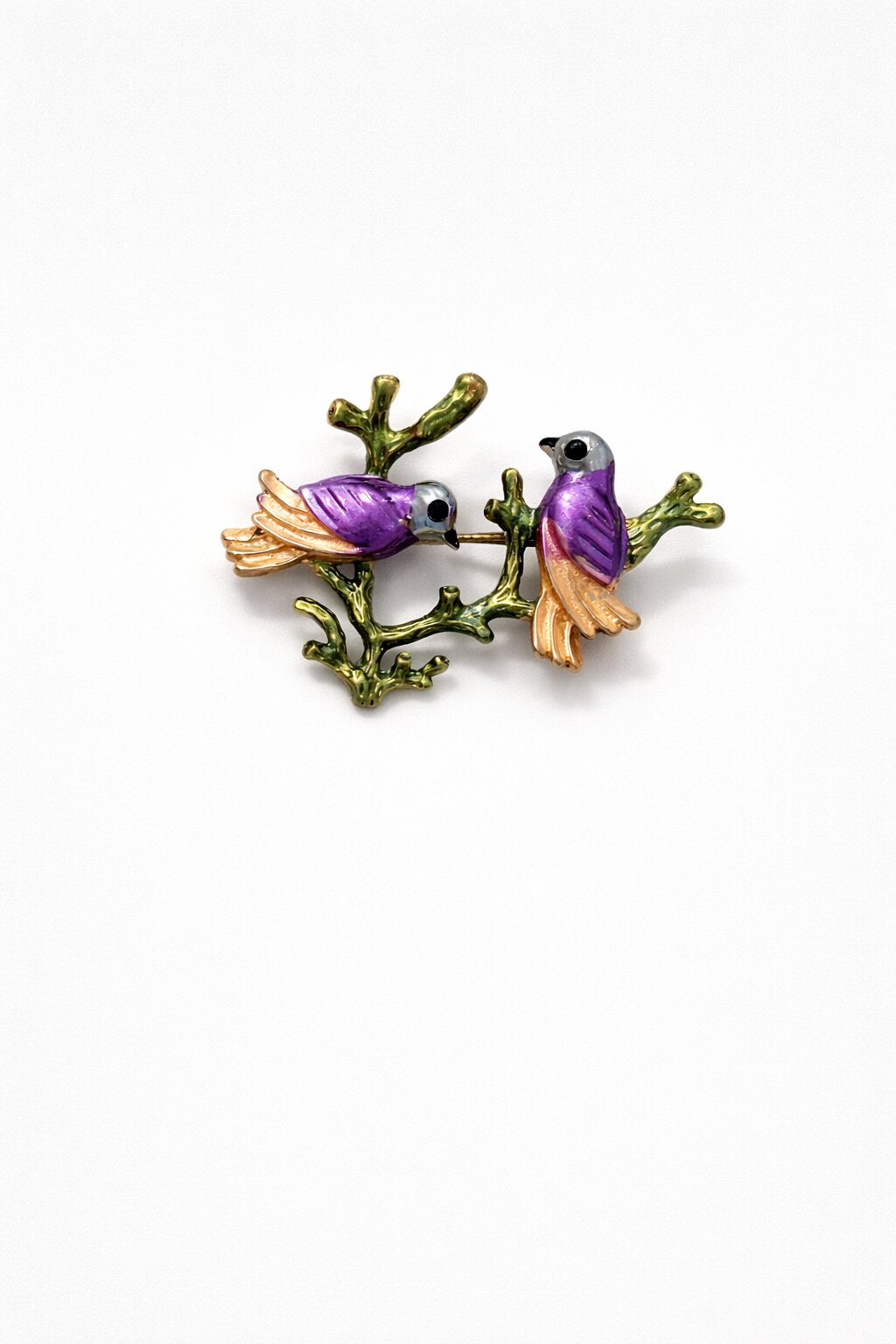 Enamel brooch with two purple birds perched on a green branch with gold-tone details.