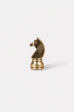 Gold knight chess piece brooch with polished metallic finish and detailed design.