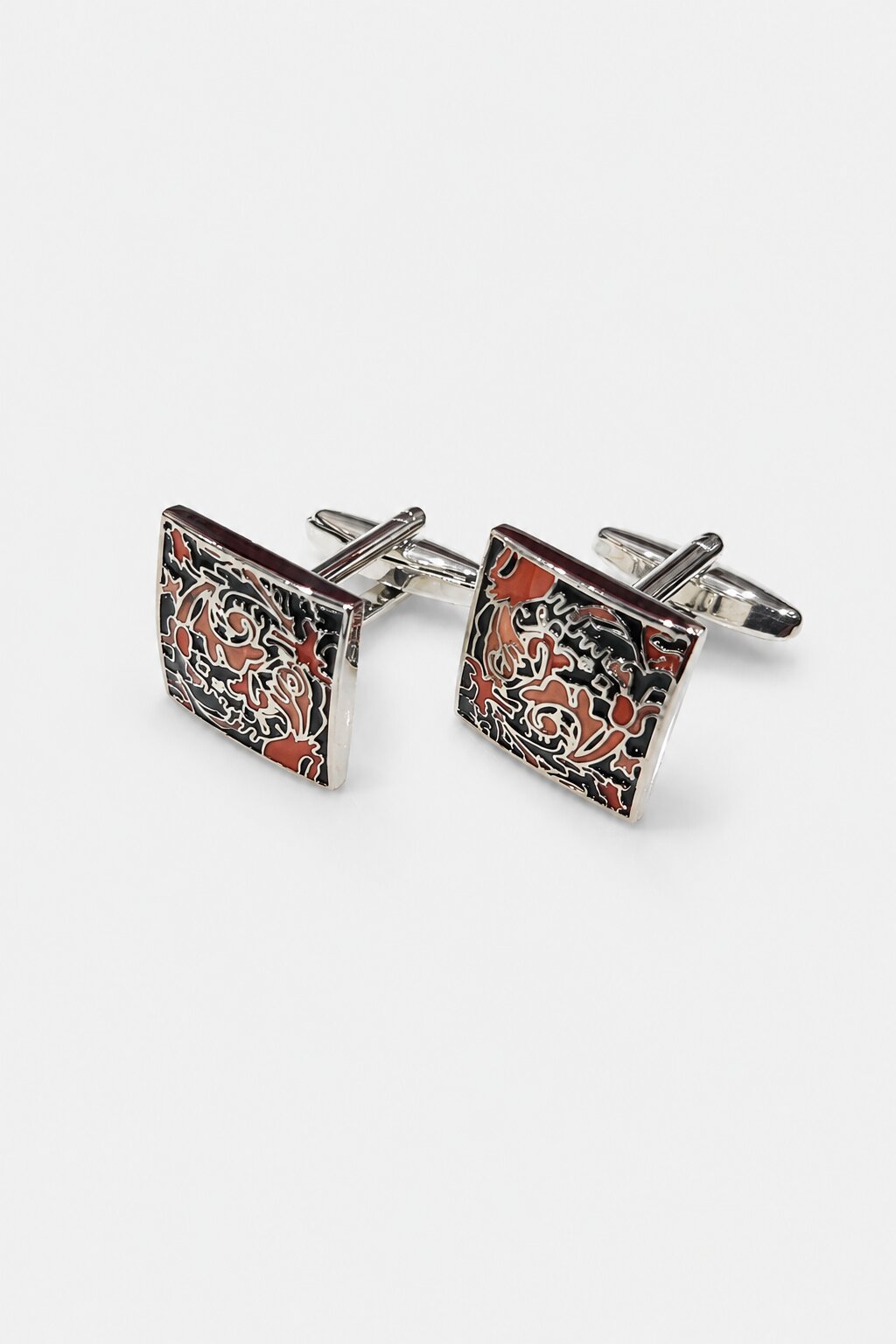 Square silver-tone cufflinks with intricate multicolor enamel artwork in black, red, and ivory shades.