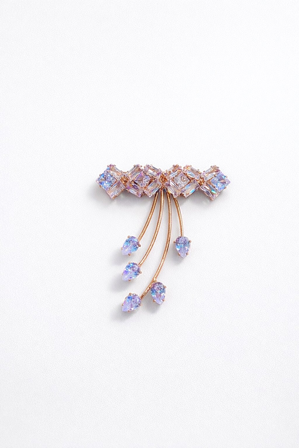 Rose gold crystal brooch with iridescent geometric stones and cascading teardrop crystal accents in a modern elegant design.