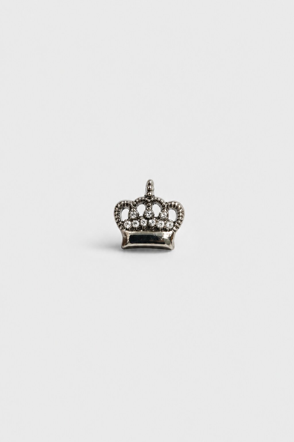 Silver crown brooch with crystal stones and polished metallic finish.