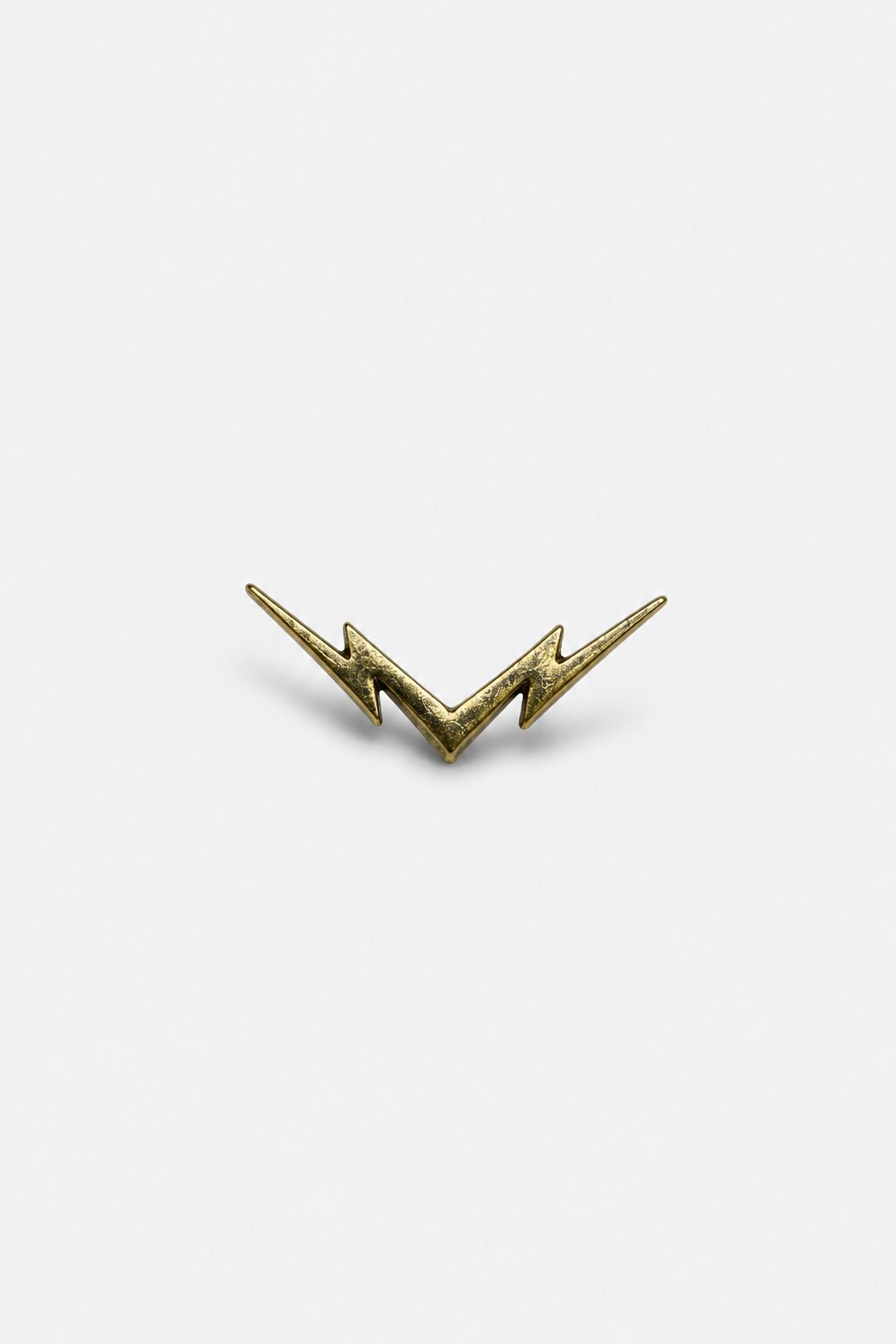 Gold-tone lightning bolt brooch with sleek minimalist zigzag design and metallic finish.