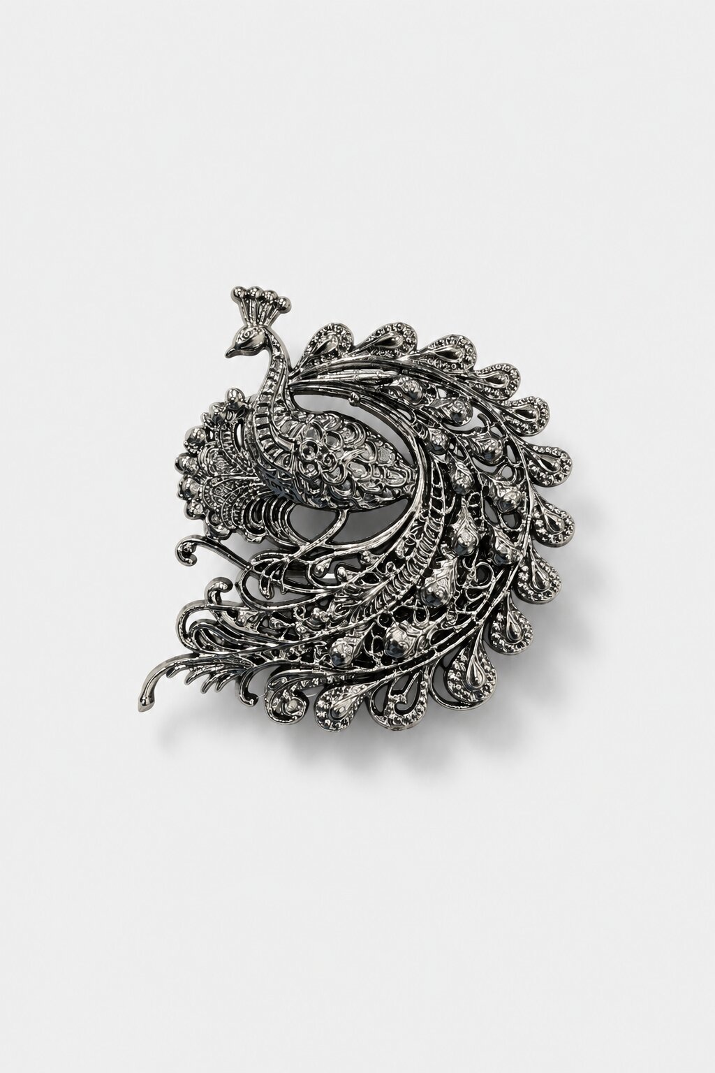 Antique silver peacock brooch with intricate filigree detailing and ornate feather design inspired by royal Indian heritage.