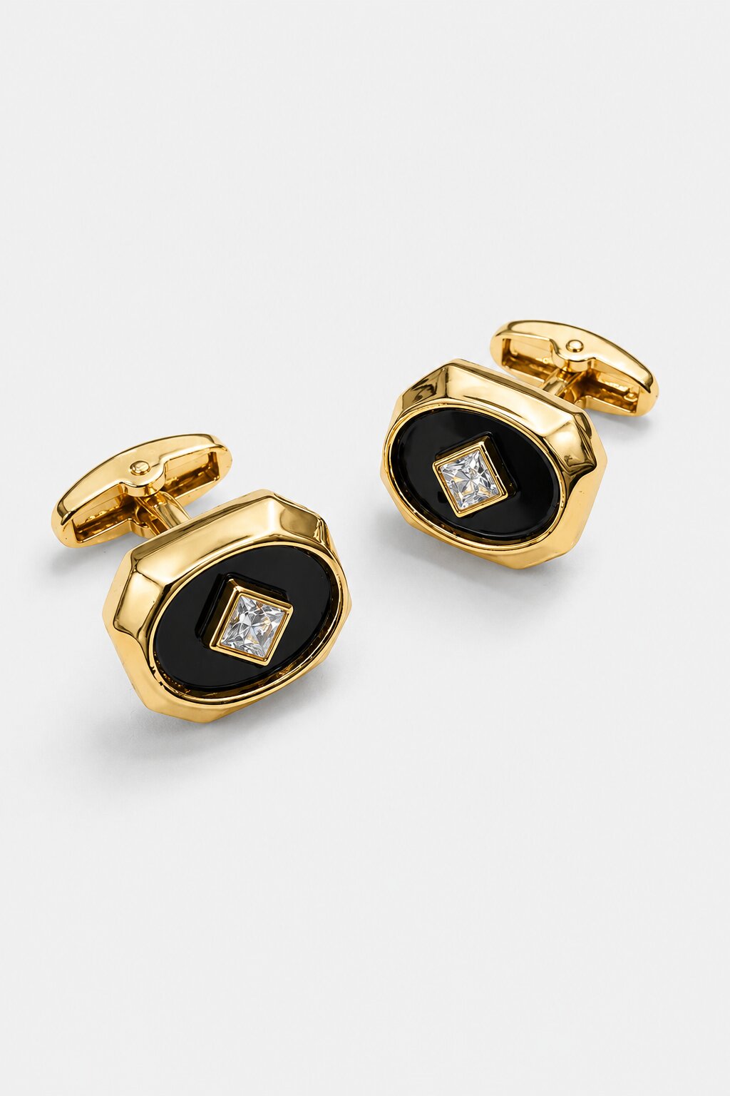 Gold octagonal cufflinks with black enamel center and square crystal accent in a polished luxury finish.