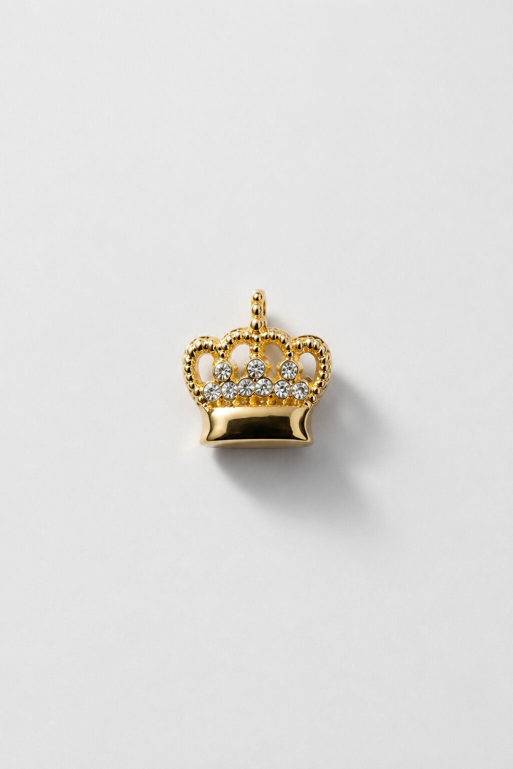 Gold crown brooch with crystal embellishments and polished premium finish.