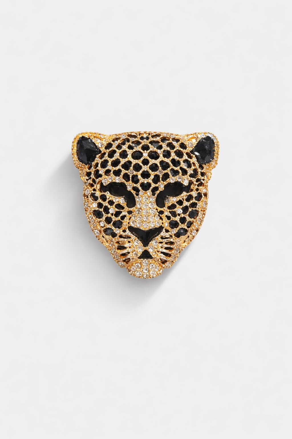 Gold-tone leopard head brooch adorned with clear and black crystals in a luxurious animal-inspired design.