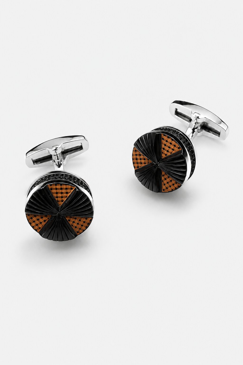 Round silver-tone cufflinks with black textured surface and bronze geometric accents for men's formal shirts.