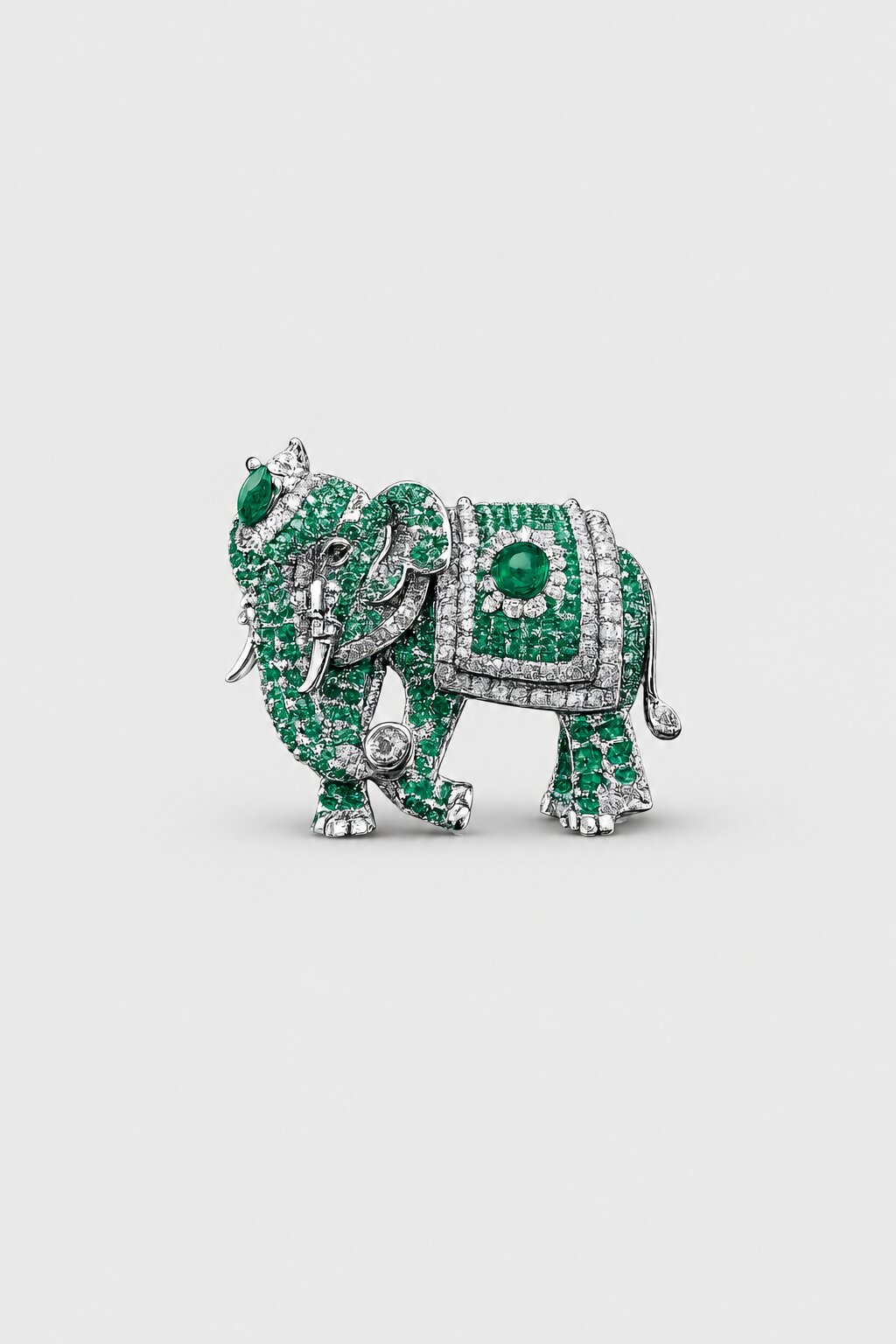 Green elephant brooch with crystal embellishments and emerald-colored gemstone accents.