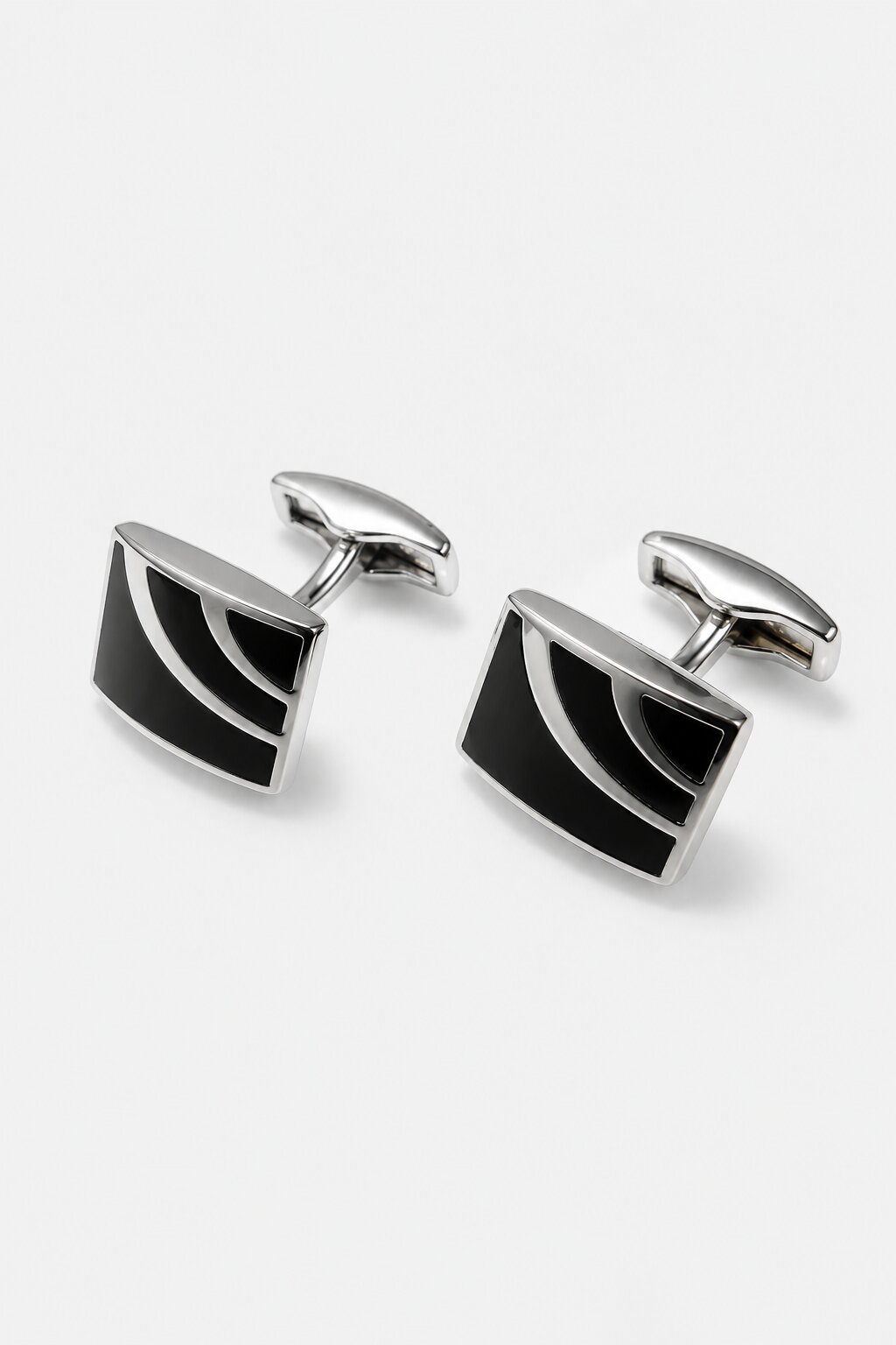 Black and silver rectangular cufflinks with curved geometric detailing and polished metal finish.