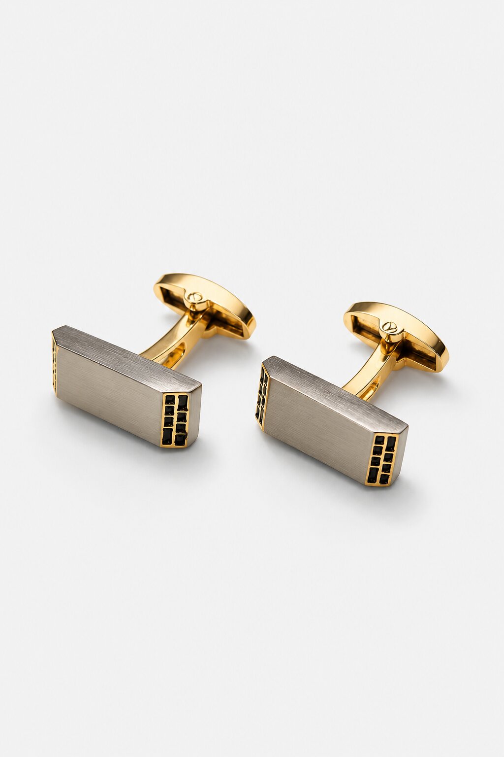 Two-tone rectangular cufflinks with brushed silver face, gold-tone hardware, and black accent detailing.