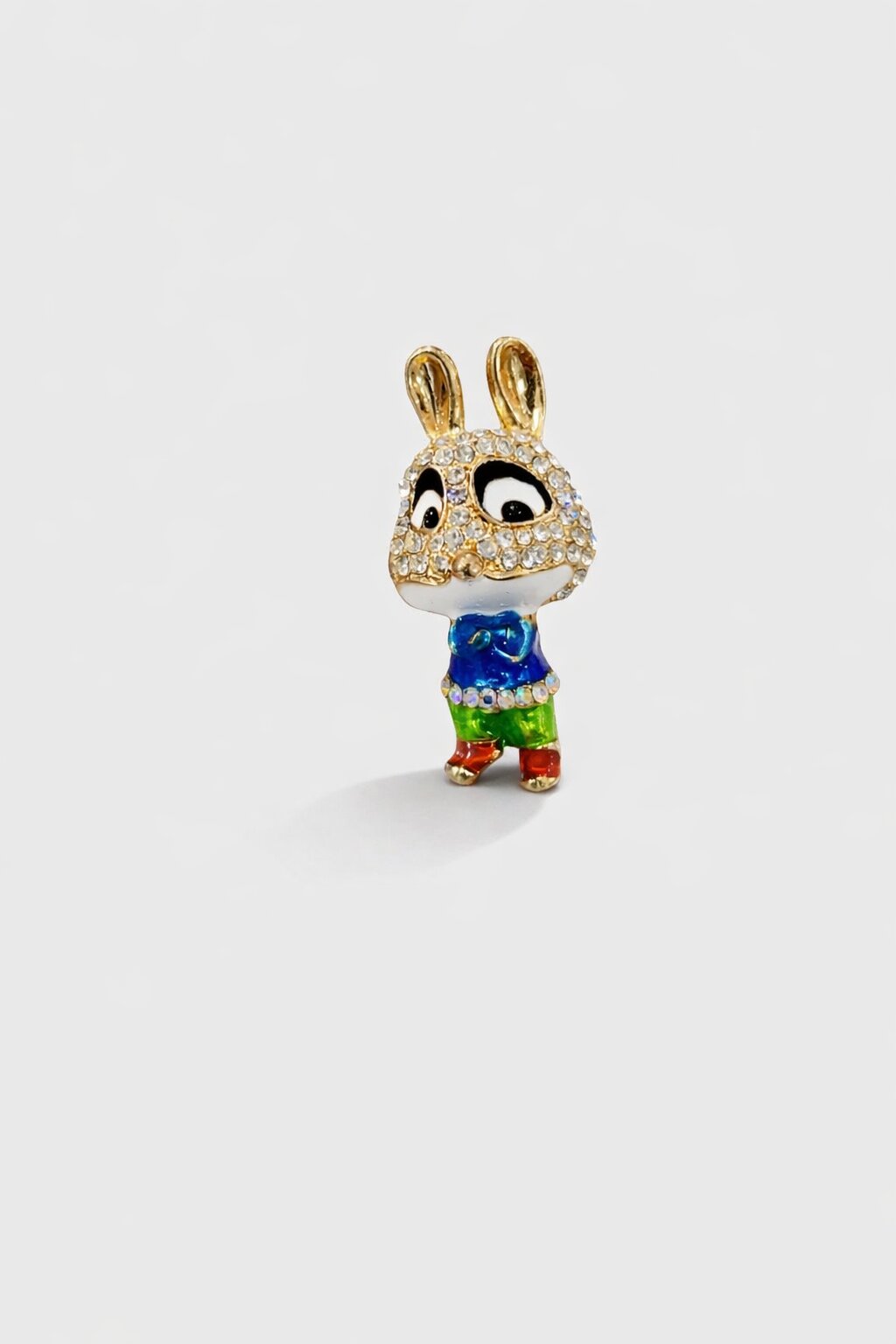 Cute rabbit brooch with crystal-studded face, blue shirt, green pants, and gold-tone details.