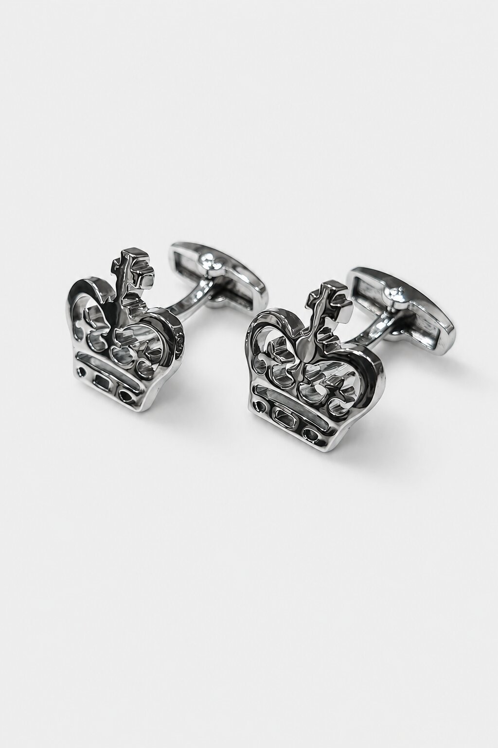 Silver-tone crown-shaped cufflinks with intricate royal detailing for men's formal accessories.