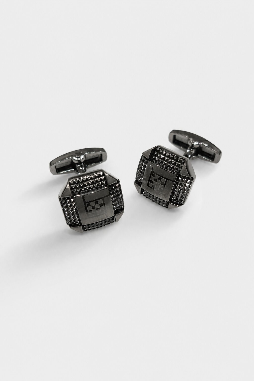 Gunmetal square cufflinks with textured geometric detailing and modern architectural design.