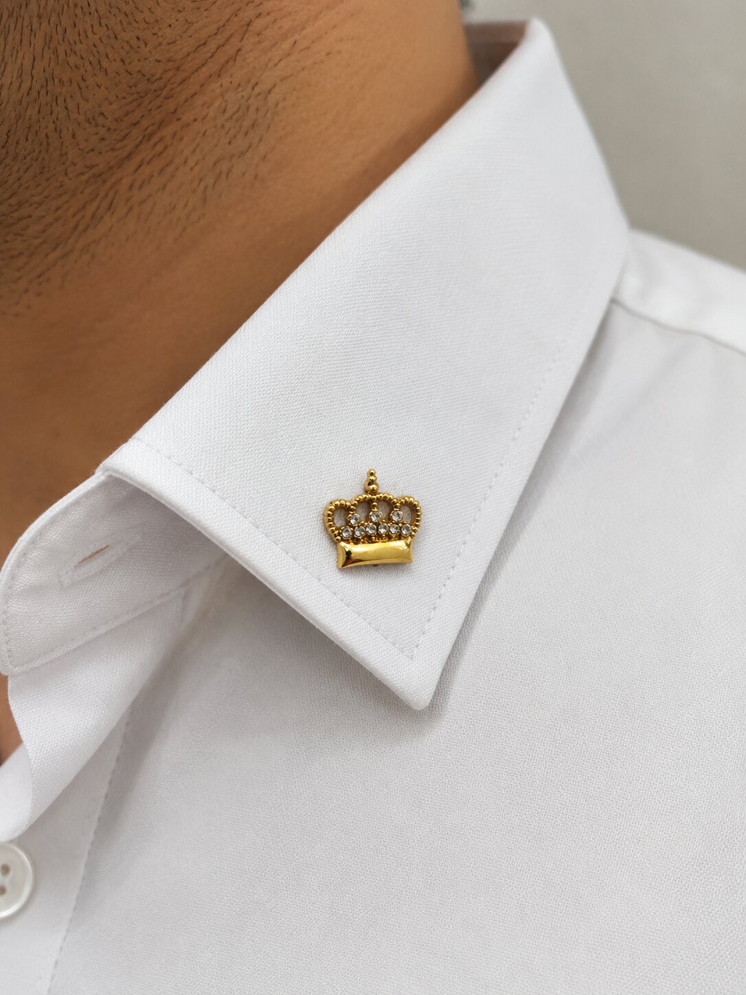 Gold crown brooch with crystal embellishments and polished premium finish.
