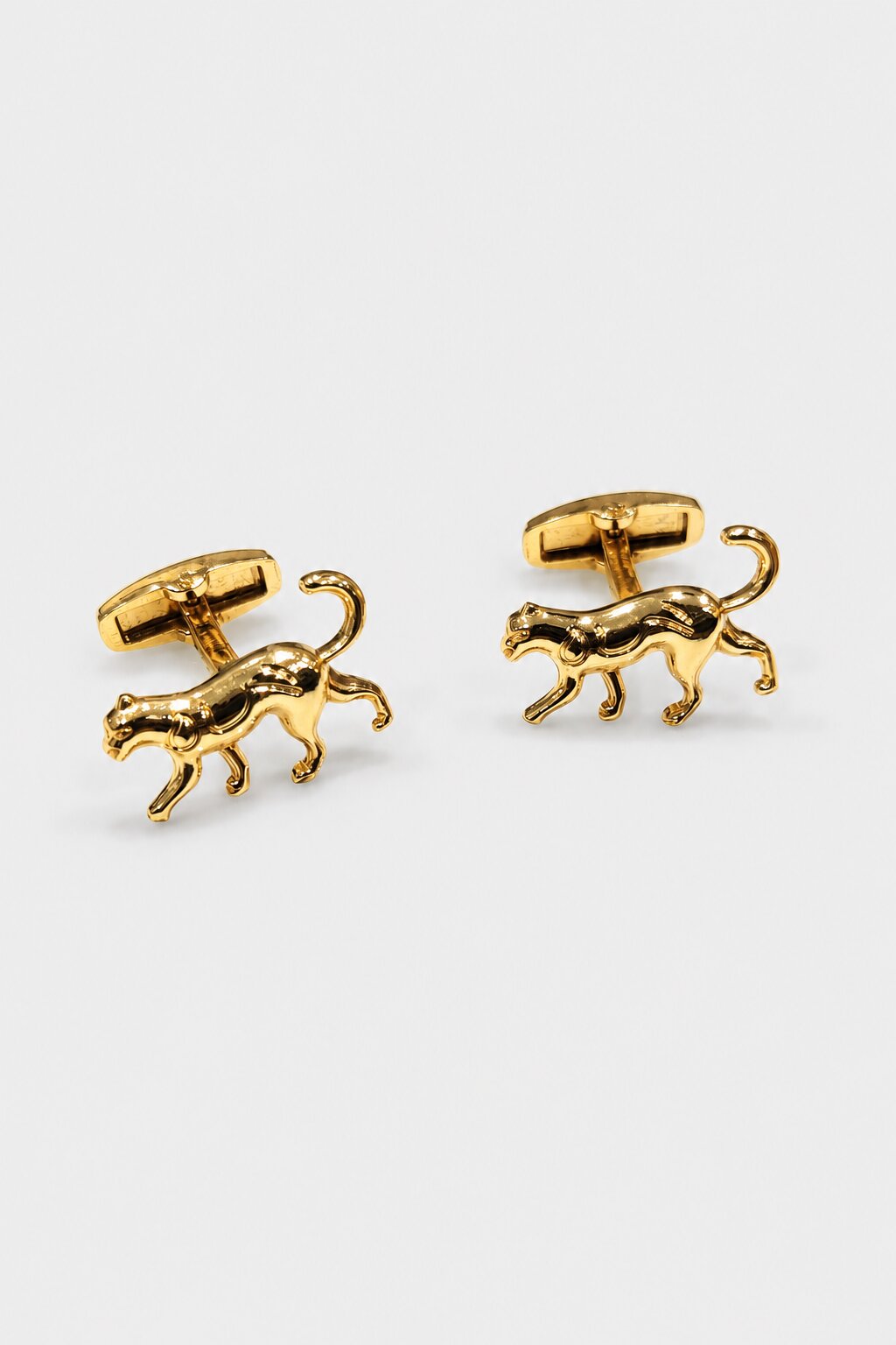 Gold-tone panther shaped cufflinks with polished finish for men's formal wear.