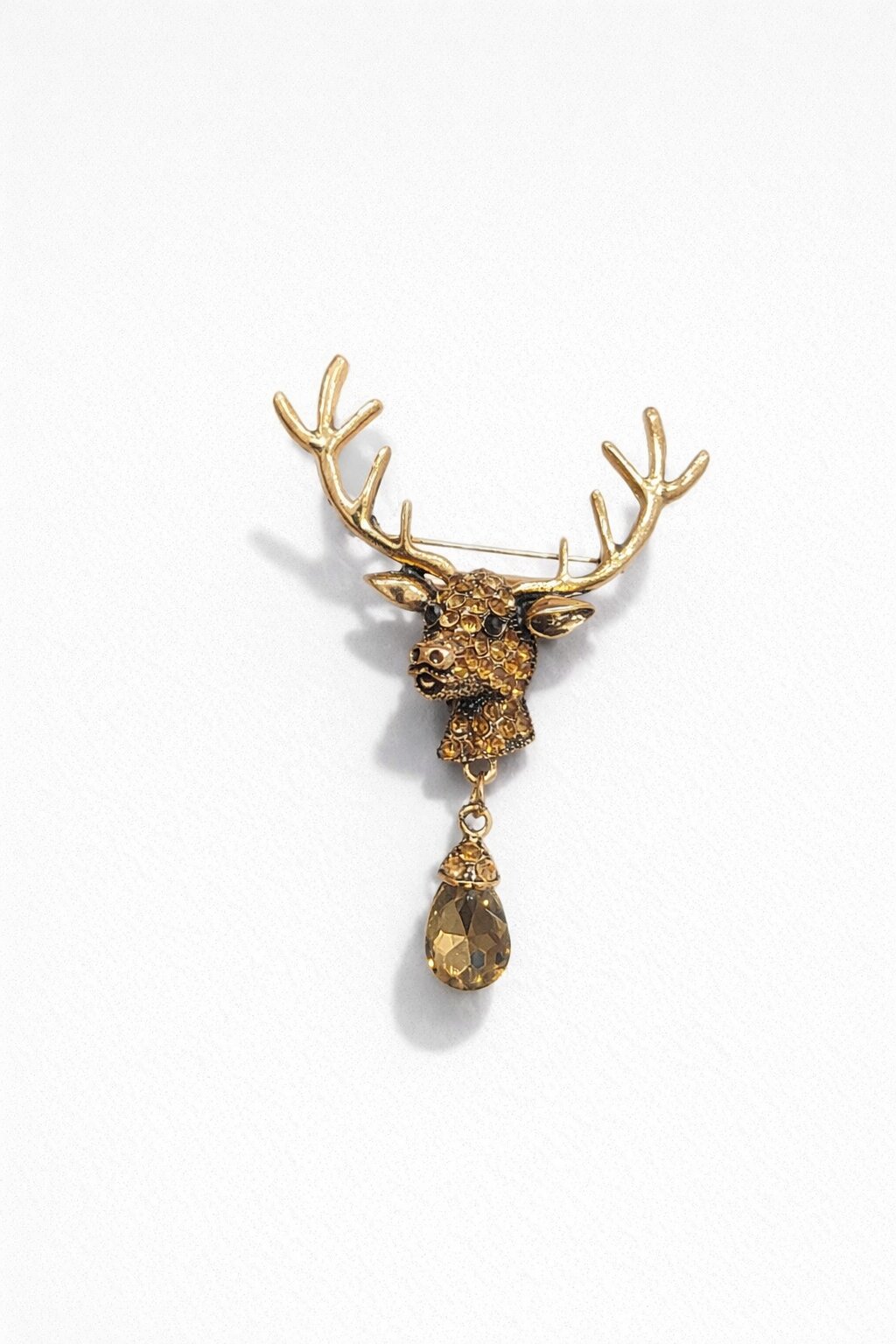 Gold-tone deer head brooch with detailed antlers, amber crystals, black eyes, and dangling teardrop crystal pendant.