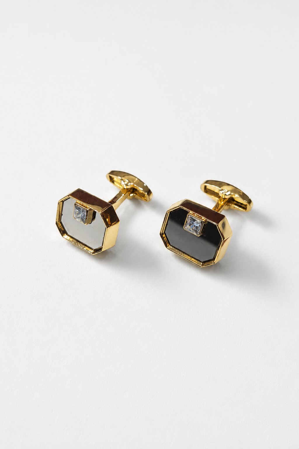 Gold octagonal cufflinks with black enamel face and crystal accent in a polished luxury finish.